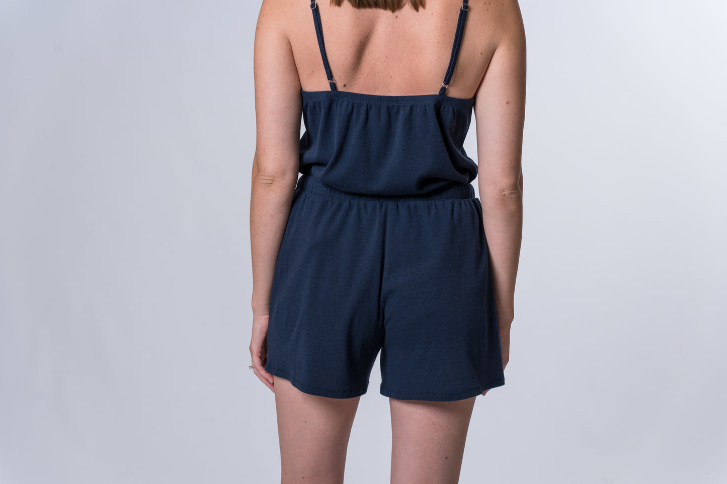 Load image into Gallery viewer, Woman wearing navy blue drawstring lounge shorts with matching tank top. Back of clothing is being shown
