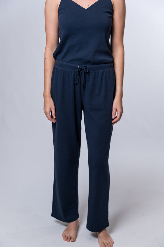 Woman wearing navy blue drawstring lounge pant and matching tank top. Front of clothing is being shown