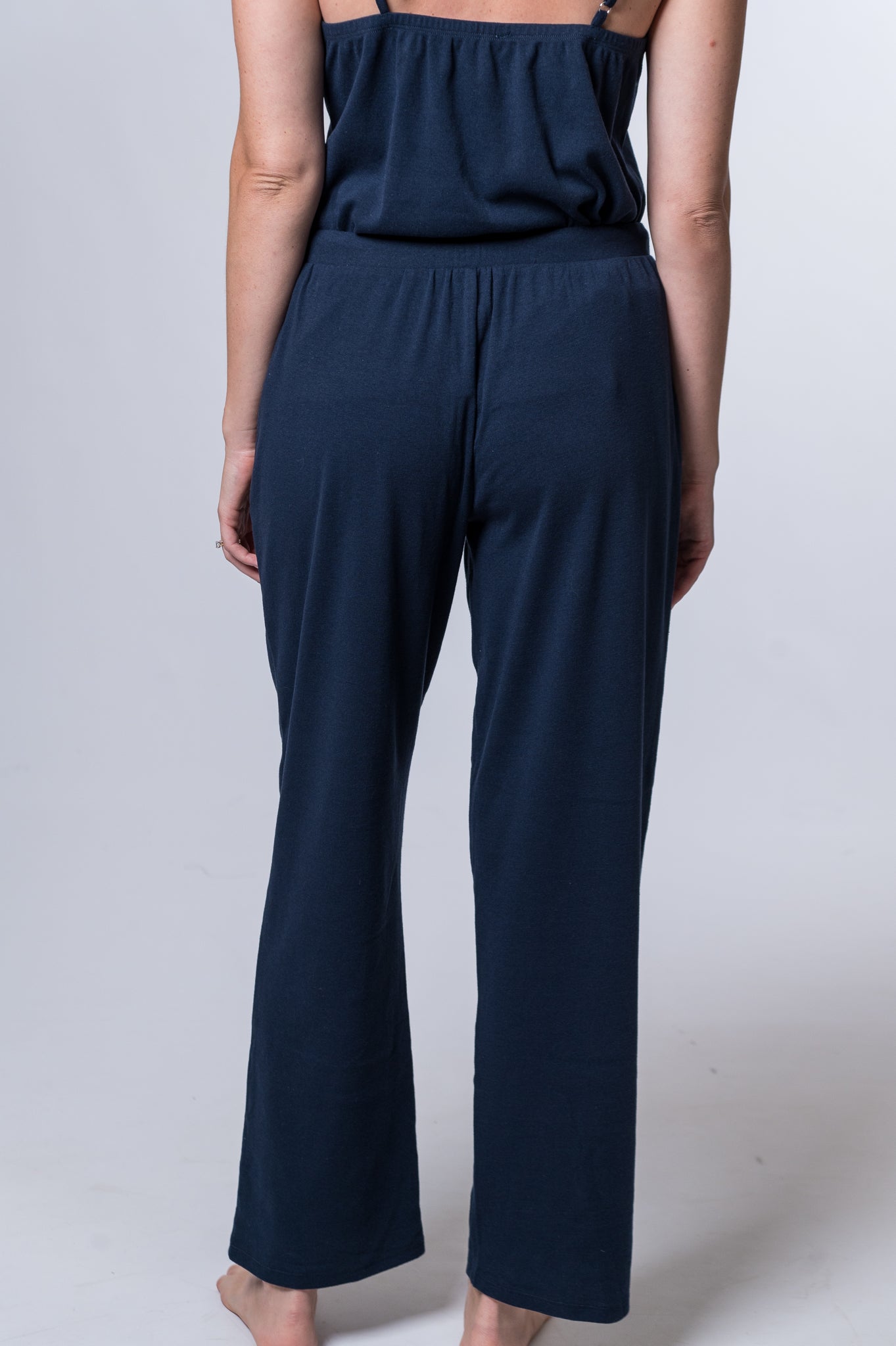 Load image into Gallery viewer, Woman wearing navy blue drawstring lounge pant and matching tank top. Back of clothing is being shown
