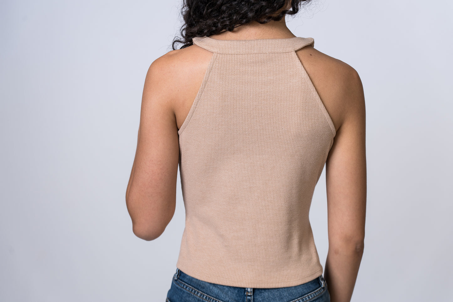 Load image into Gallery viewer, Woman wearing a tan, round neck tank top with medium wash jeans. Back of clothing is being shown
